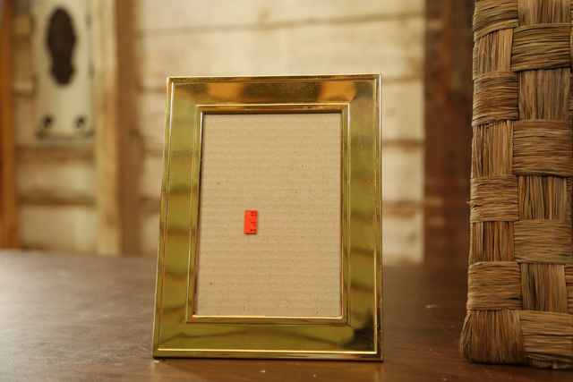 gold brass picture frame on table with orange price sticker