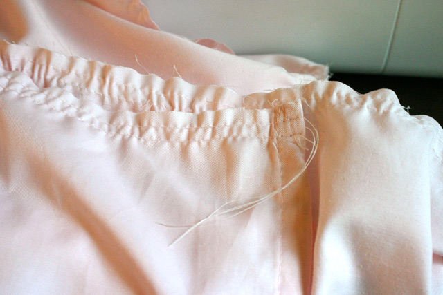 two long basting stitches on pink fabric to create ruffle