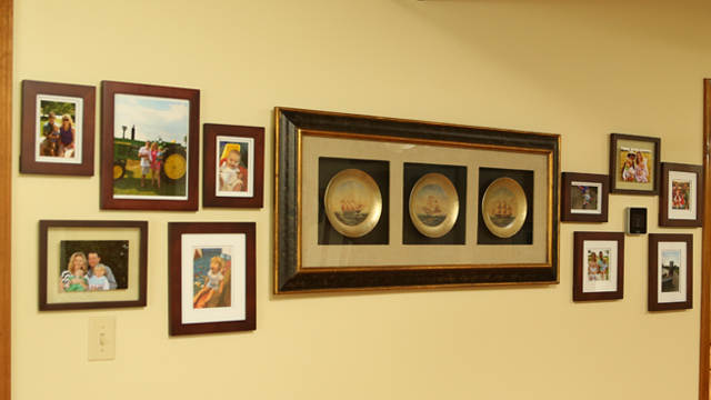 wood stained photo frames in gallery wall with carrier cor thermostat