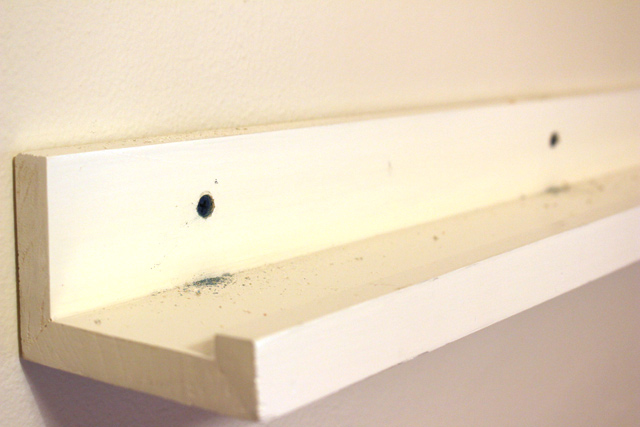 blue tapcon screws sunken in back of white wood picture ledge