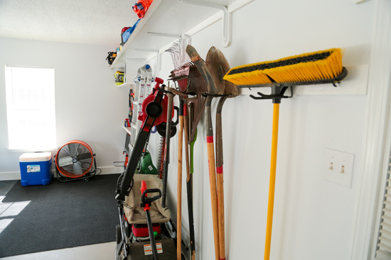 Lawn and Garden Tools Hanging on Back Wall in Garage