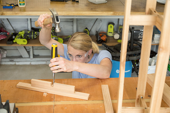 Chelsea Lipford Wolf using Dewalt wood chisel in workshop to build cedar wood planter stand