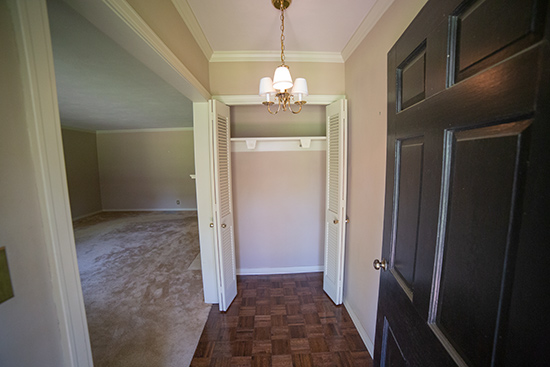 Front Foyer Entry with Parquet Wood Floors and Bi-Fold Doors Coat Closet