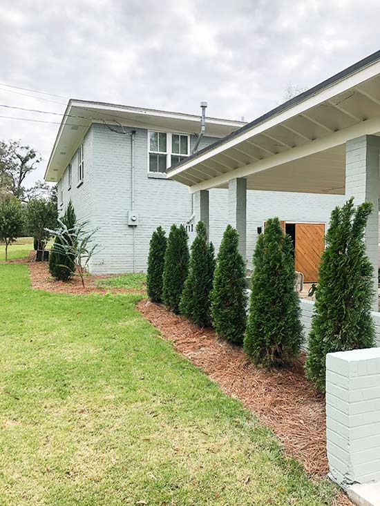 Perspective of Carport Columns with Brick House Painted in Background