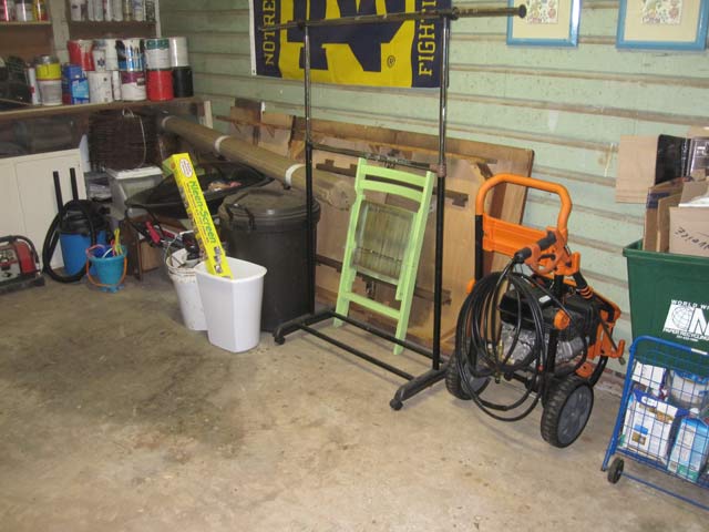 Chair power washer and other items stored on concrete floor of shed