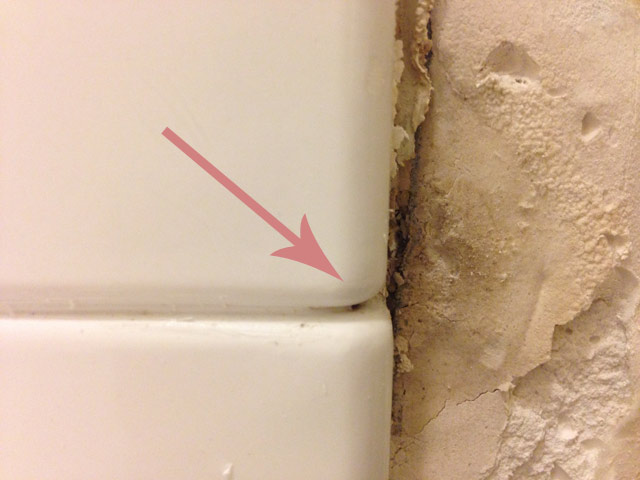 arrow pointing at bathtub caulk seam