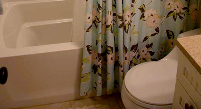 Shower curtain in small bathroom white bathtub
