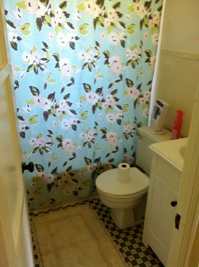 Flower shower curtain, green checkered tile, small bathroom with white vanity