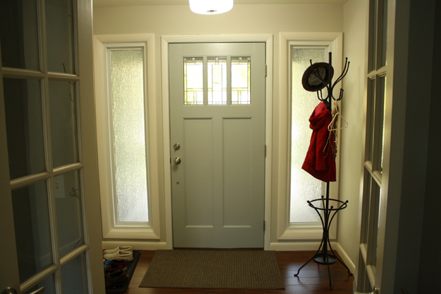 interior side of front entry door painted grey with coat hanger in corner
