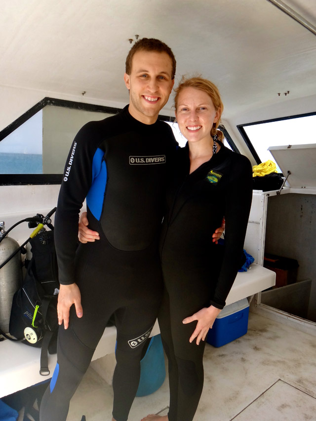 husband and wife in wet suits on boat for scuba diving Grenada