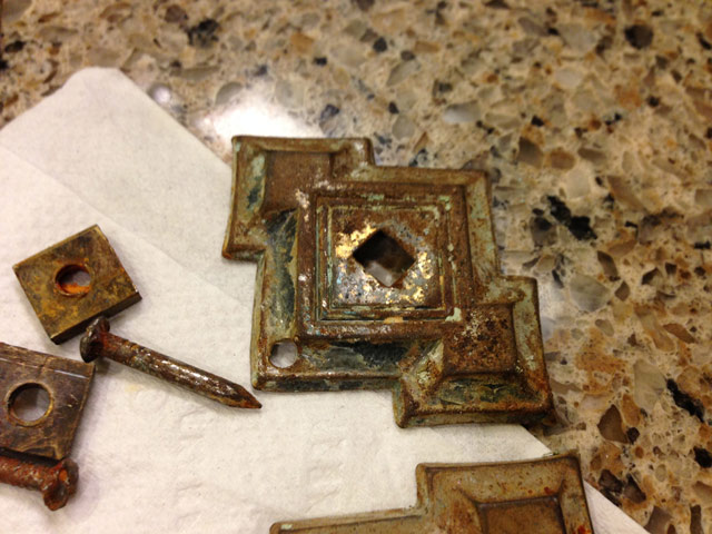 rusty drawer pulls sitting on paper towel and quartz countertop
