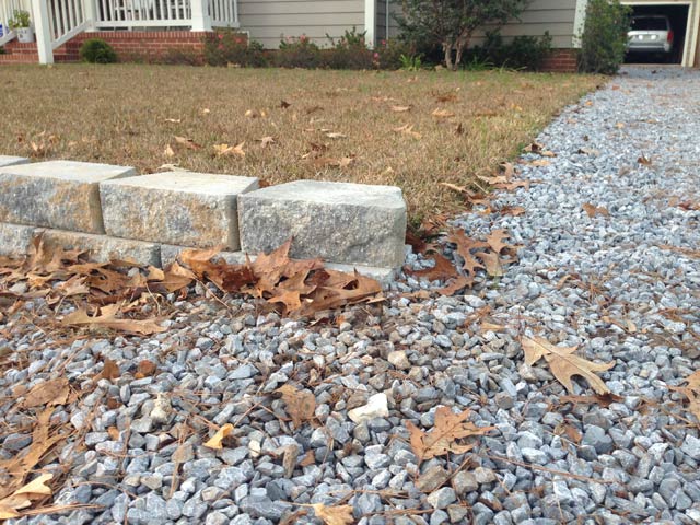 completed run of retaining wall blocks at gravel driveway