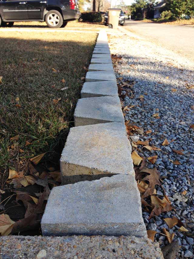 close up of pavestone yukon rockwall retaining wall blocks in place at concrete sidewalk