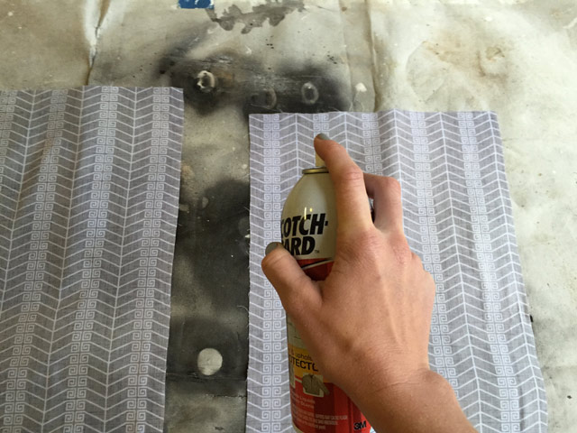 hand holding and spraying Scotchgard spray can on fabric