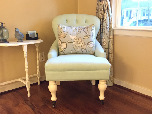 robbins egg blue tufted chair in corner of living room with blue floral curtains on window