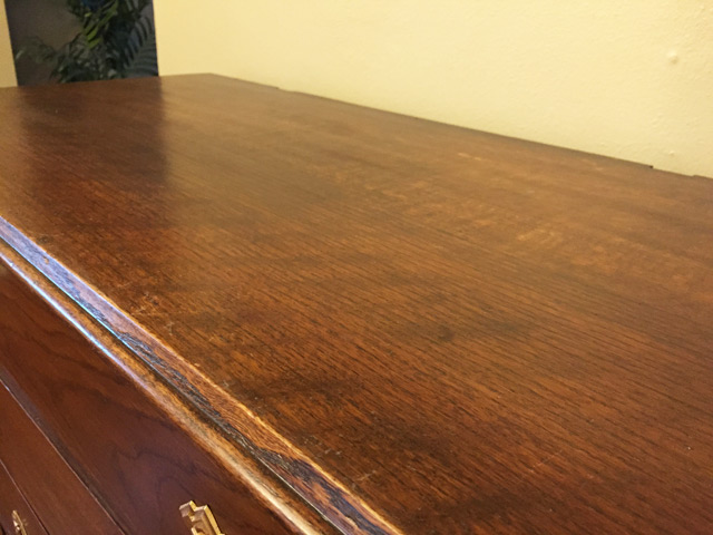 shiny surface of stained wood dresser with polyurethane in yellow room