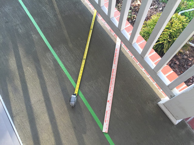 tape measure yard stick green painter's tape on concrete porch