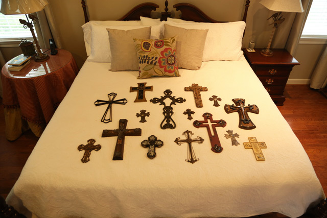 metal cross wood crosses laying on king white bed cover