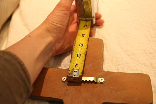 tape measure picture hanger on back of cross