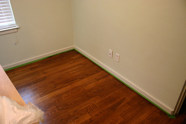 green frogtape painter's tape on shoe molding stained wood floors