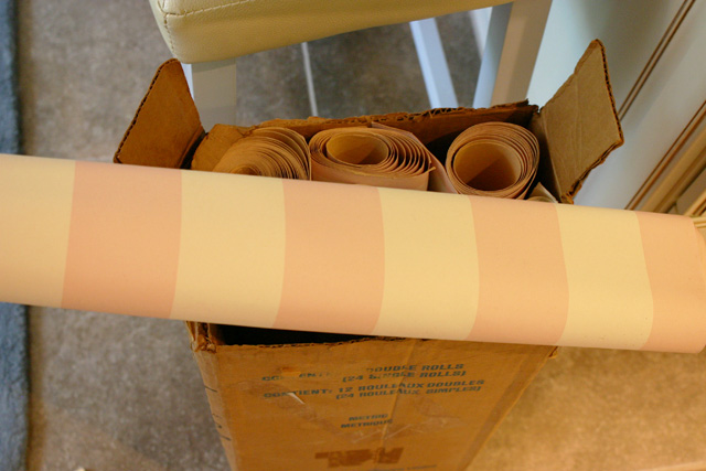 pink and white striped wallpaper rolls in box
