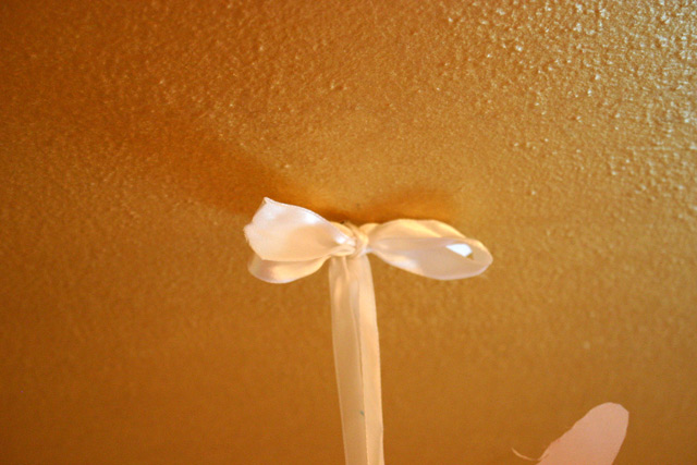 white silk ribbon bow hanging from ceiling