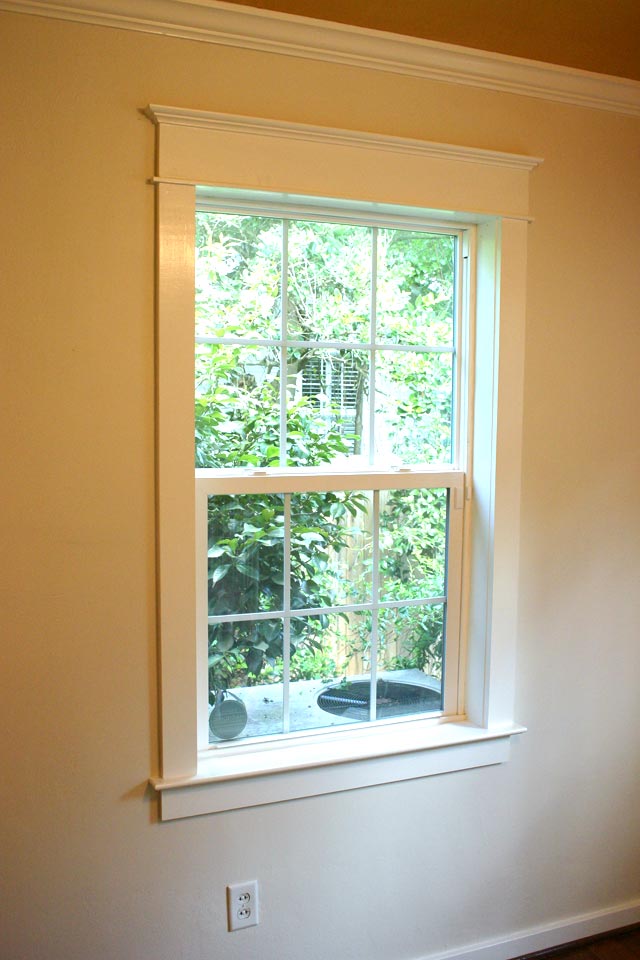 craftsman style window trim in room with white walls gold ceiling