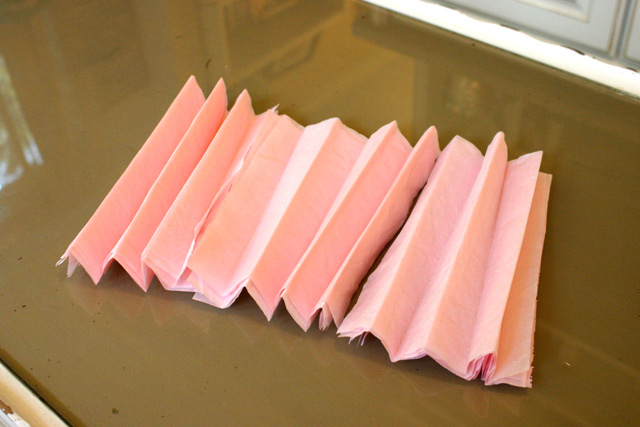 pink tissue paper folded accordion style on glass coffee table
