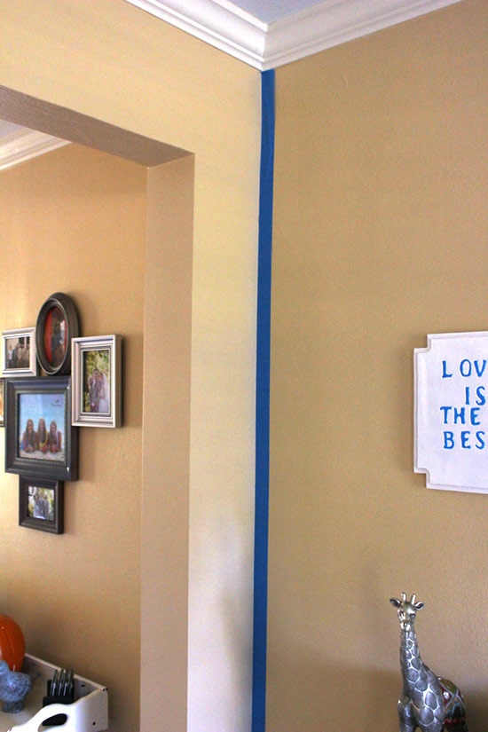blue painter's tape in corner of yellow walls