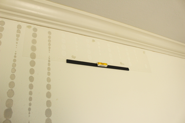 top stencil with level on wall