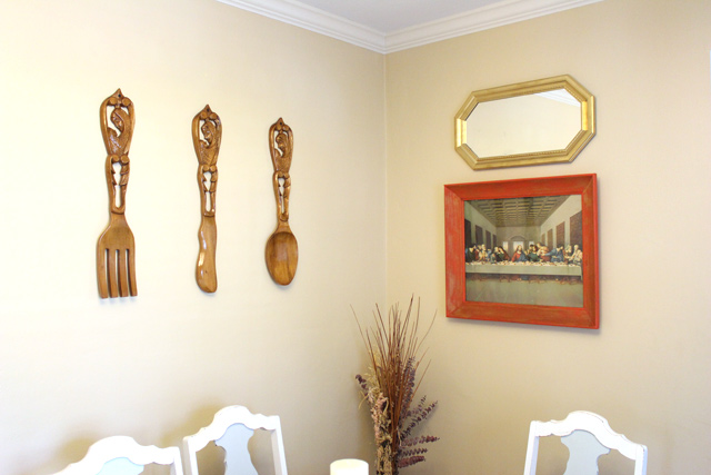 wooden utensils last supper and gold mirror hanging in dining room