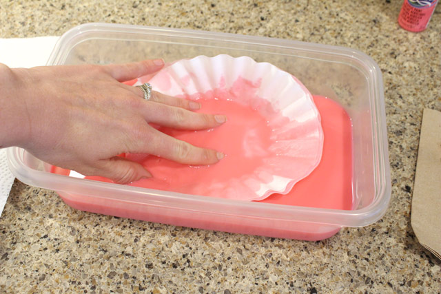 hand dipping coffee filters in pink paint