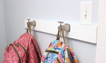 brushed nickel robe hooks backpack hanging system in organized laundry room