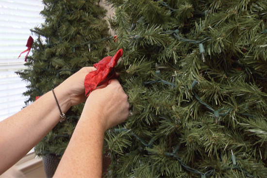 Adding Red Bows to DIY Christmas Garland Topiary
