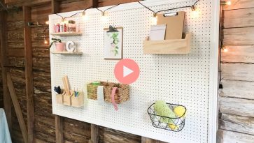 white painted pegboard hanging in garage with frame and custom bins hanging on pegs