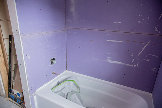Purple Drywall Around New Bathtub Before Wall Paneling
